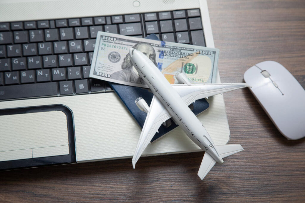 A small plane with dollar bills on a laptop